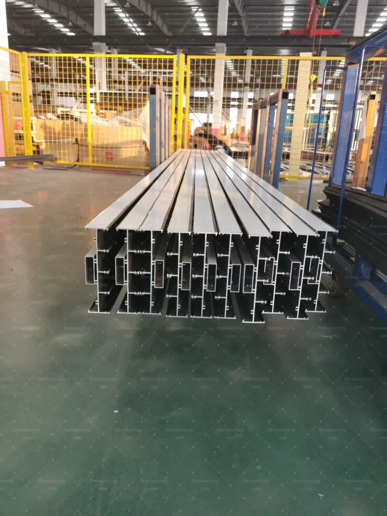 Aluminum window profile extrusions stacked for QC at China factory — Florida luxury hotel project