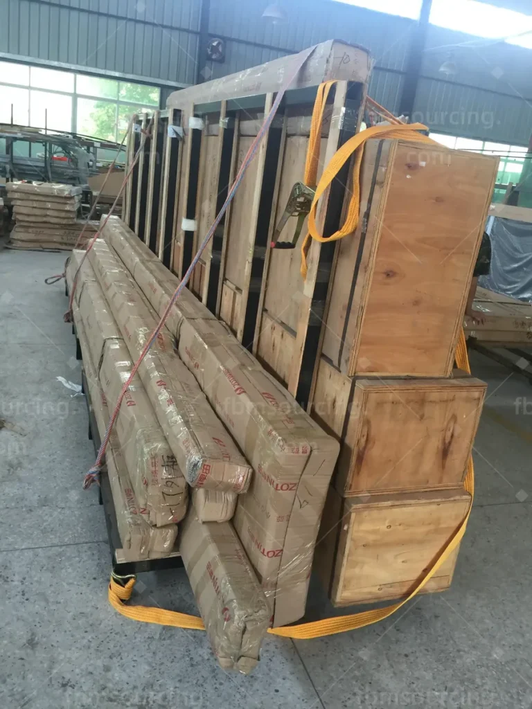Crated and film-wrapped door units secured on a transport rack in the loading area