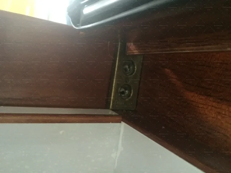 Corner bracket hardware inspected on a timber-look door frame during quality control