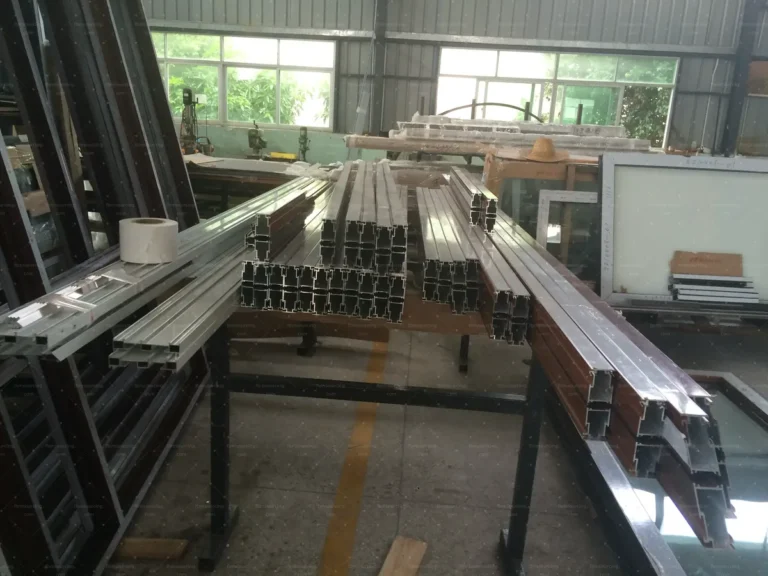 Cut aluminium profiles queued on fabrication benches during production follow-up