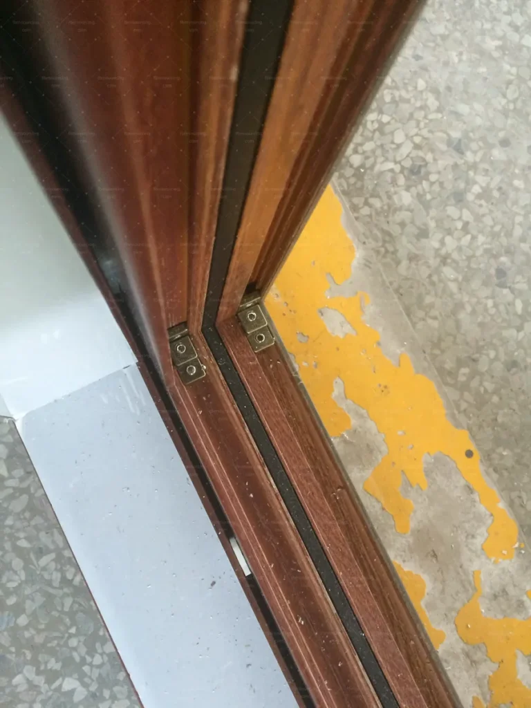 Friction stay hardware and corner detail inspected on an awning window sash