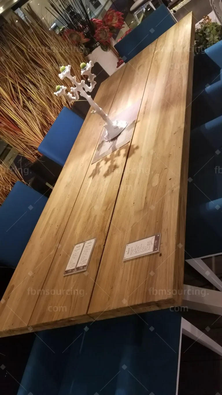 Solid teak outdoor dining table inspected during sourcing trip