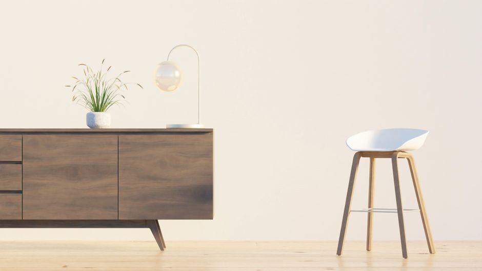 Modern minimalist interior featuring a wooden sideboard, chair, lamp, and plant against a white wall.