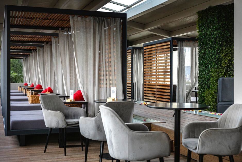 Elegant indoor lounge area with curtain-divided seating and plush chairs.