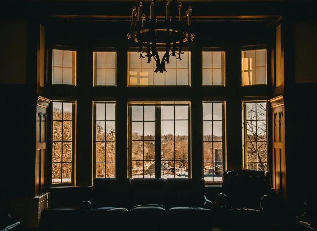 Warm interior with large windows overlooking a scenic outdoor view.