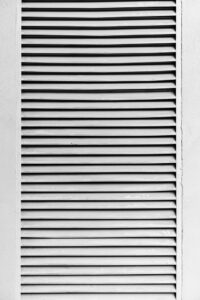 Black and white photo of louvered panel showcasing high contrast lines and textures.