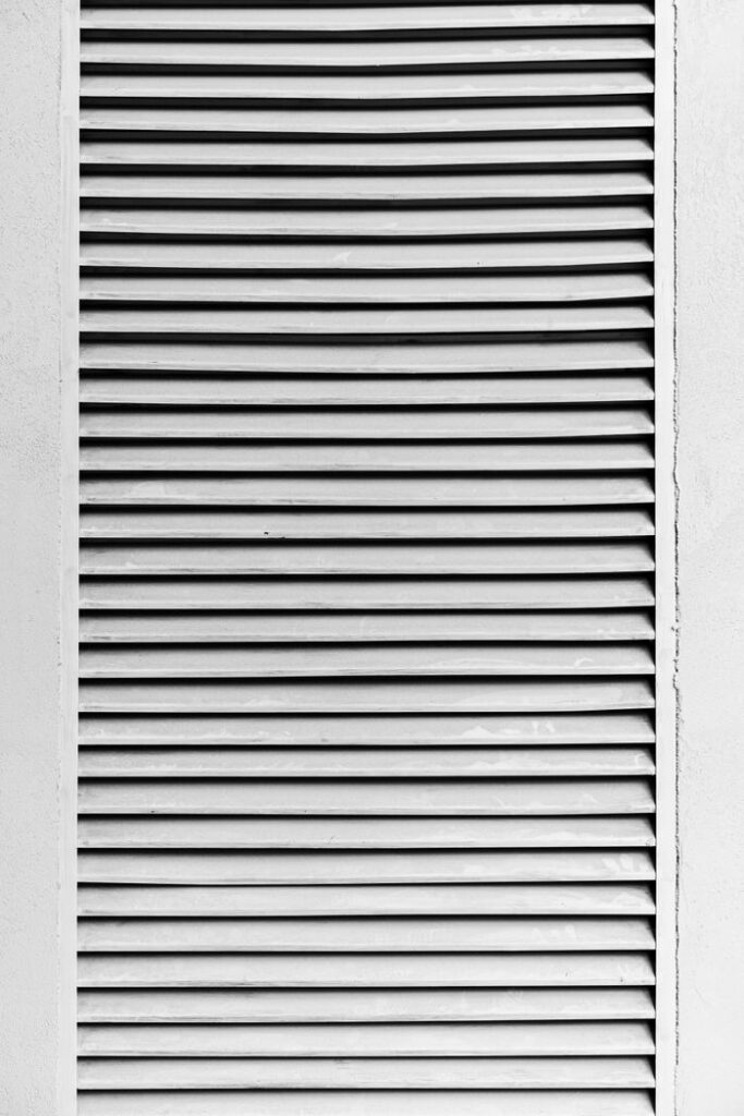 Black and white photo of louvered panel showcasing high contrast lines and textures.