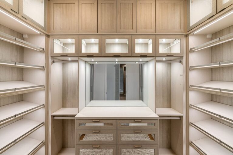 Spacious walk-in closet with wooden cabinets and ample lighting.
