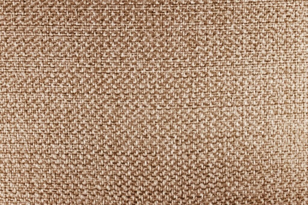 Detailed close-up of beige fabric texture, highlighting its woven pattern.