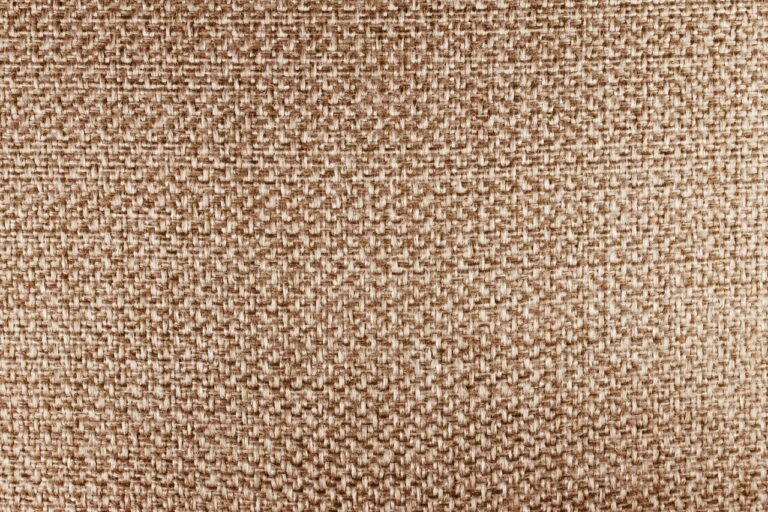 Detailed close-up of beige fabric texture, highlighting its woven pattern.