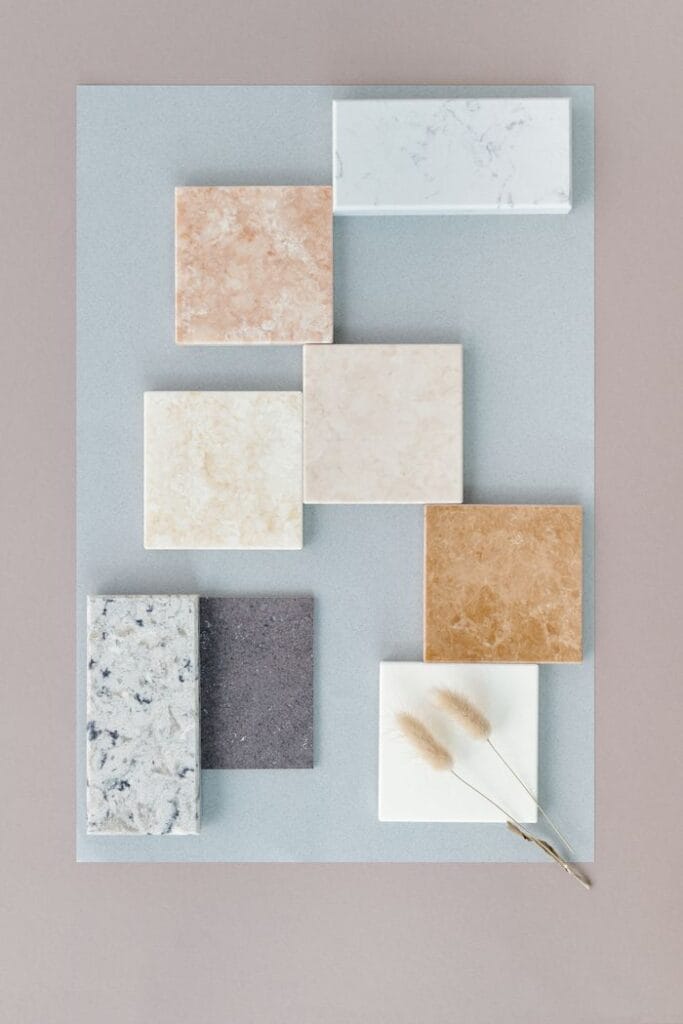 Flat lay of various marble tiles arranged on a soft neutral backdrop for design inspiration.
