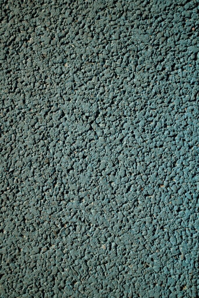 Detailed close-up texture of an asphalt pavement with a rough, granulated surface.