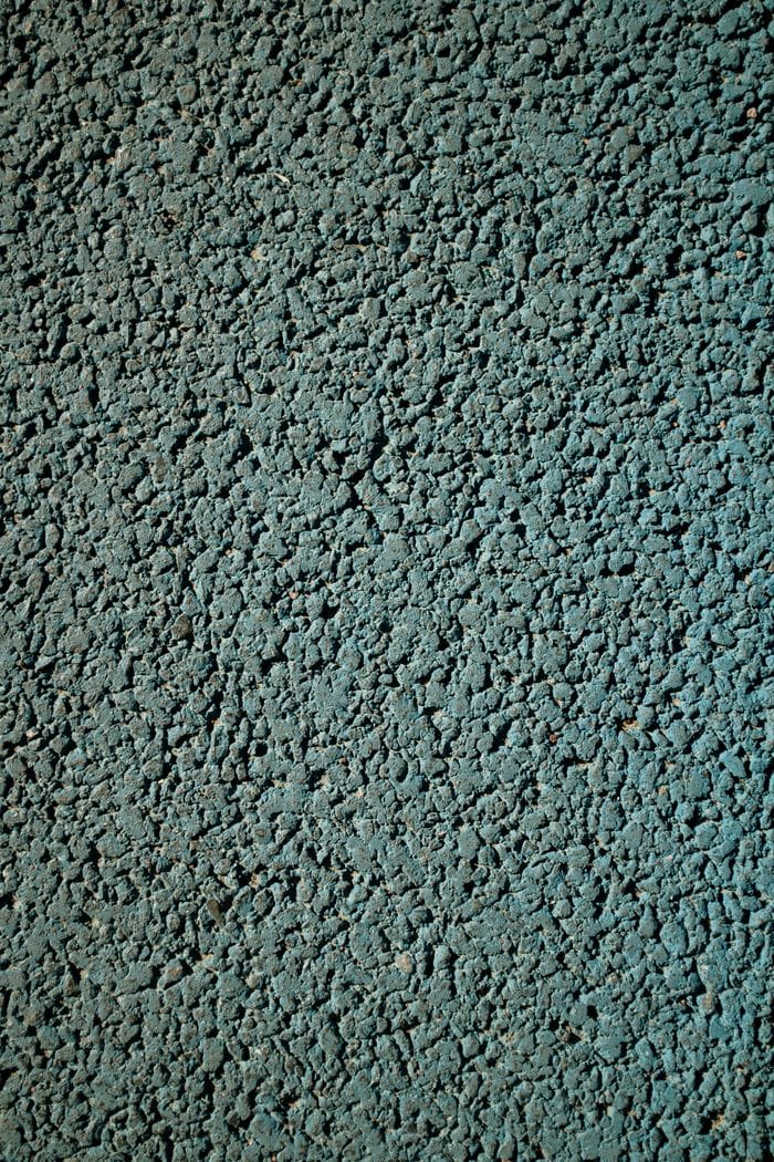 Detailed close-up texture of an asphalt pavement with a rough, granulated surface.