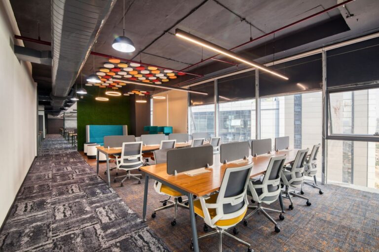 Spacious and modern open office interior with desks and chairs, ideal for business environments.