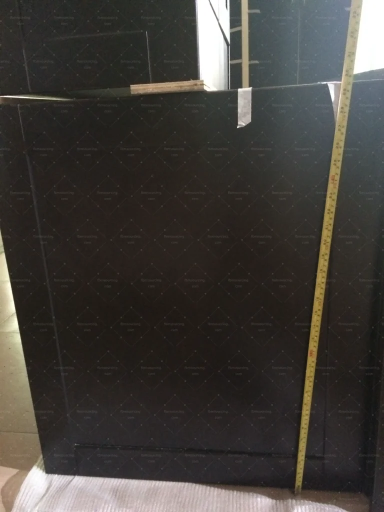 Dark hardwood cabinet door checked for finish consistency during inspection