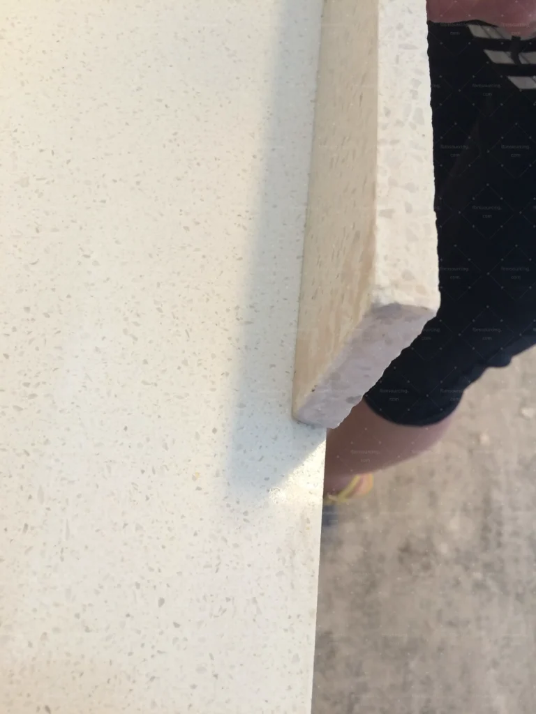 Quartz countertop edge profile checked by hand during stone inspection