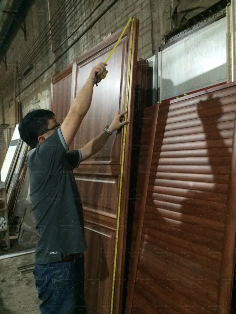 Inspector checking louver wardrobe doors at a China door factory