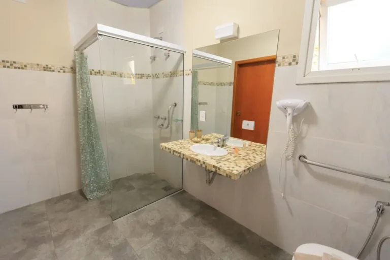 Accessible hotel bathroom with grab bars and roll-in shower for ADA compliance on US hotel FF&E