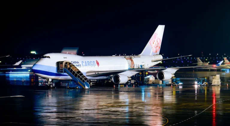 Cargo aircraft being loaded at night, illustrating air freight versus sea freight on a China project order
