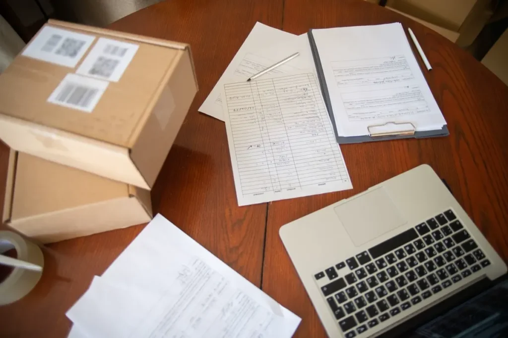 Export shipping documents and a carton on a desk, illustrating how a certificate of origin affects import duty under an FTA