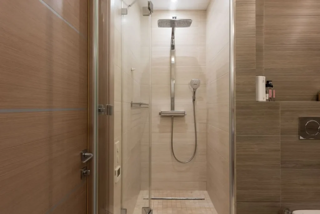 Framed vs frameless shower enclosure: glass shower door in a hotel bathroom