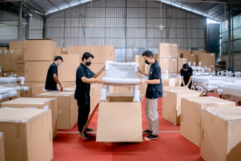 Warehouse workers protective-packing hotel FF&E furniture to prevent shipping damage and replacement claims