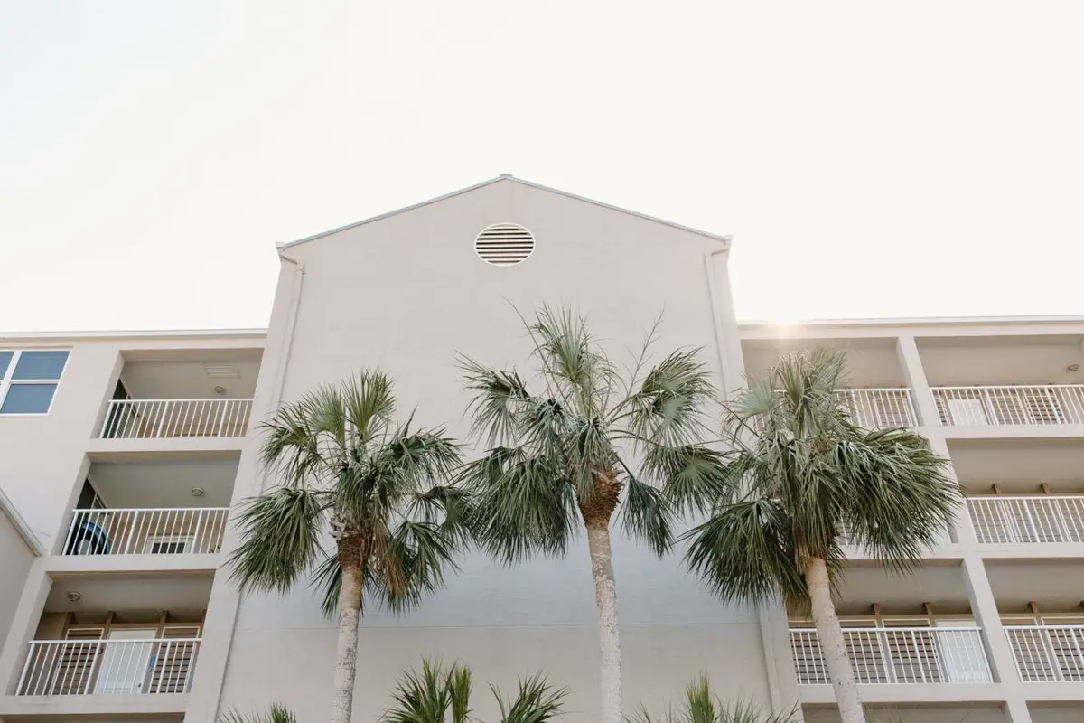 Coastal resort building with balconies and palms — hurricane and impact standards for Caribbean projects