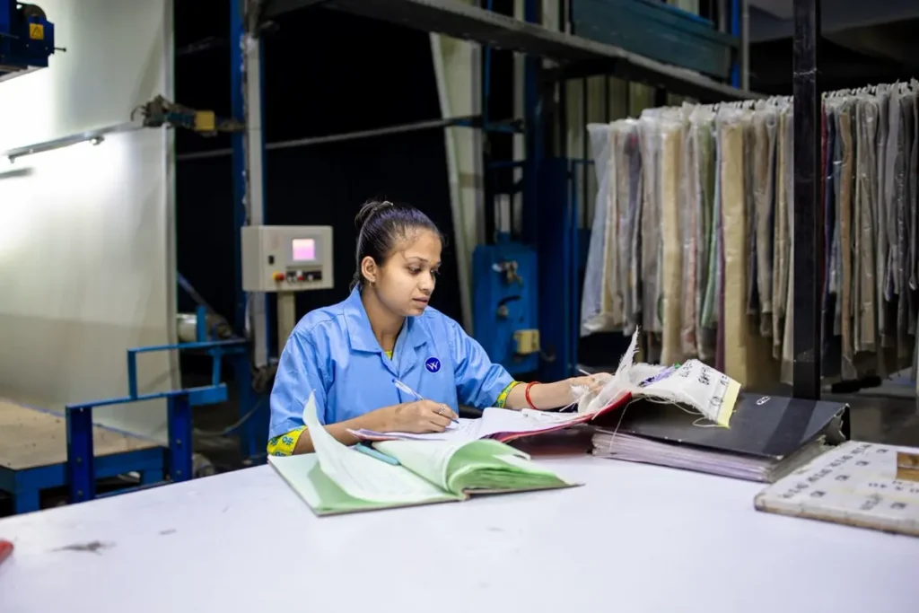 Factory quality records being checked on a production line, illustrating what ISO 9001 and ISO 14001 certificates mean on a Chinese factory quote