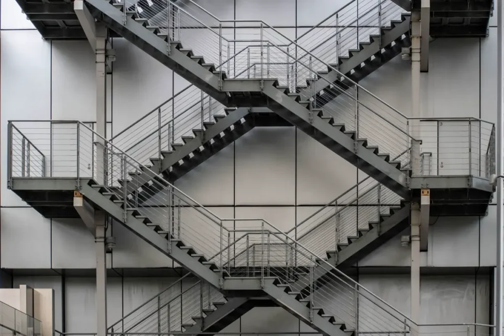 Welded steel switchback egress stairs on a commercial building - metal stairs sourcing from China