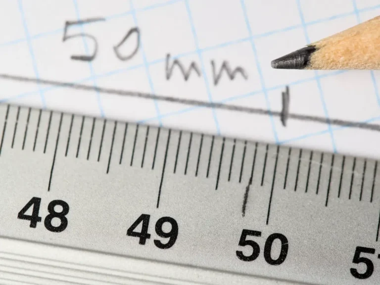 Steel rule and pencil marking 50 mm on a drawing, illustrating metric versus imperial specifications for Chinese factories