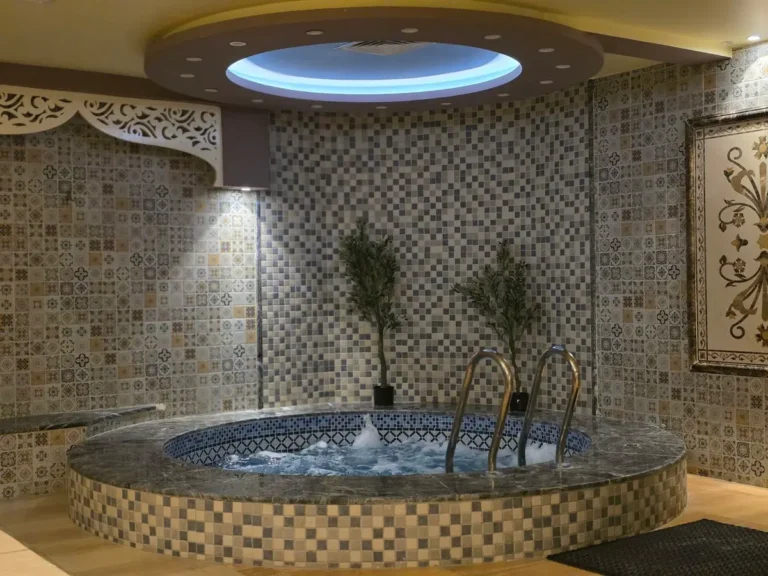 Mosaic tiled hydrotherapy pool in a hotel spa and wellness center