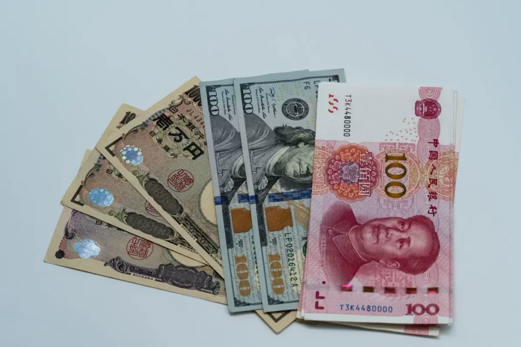 USD, RMB and yen banknotes representing exchange rate exposure on a China project order for a building materials sourcing agent