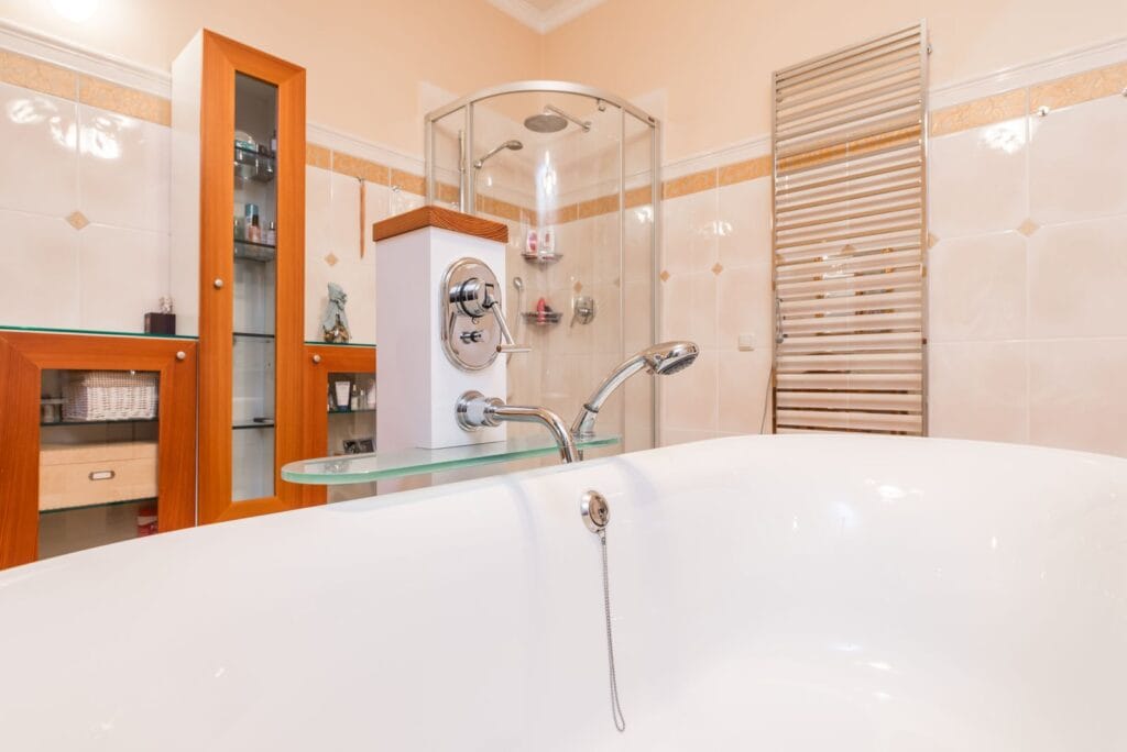 Freestanding bathtub in a contemporary hotel bathroom, illustrating acrylic vs cast iron vs solid surface bathtubs