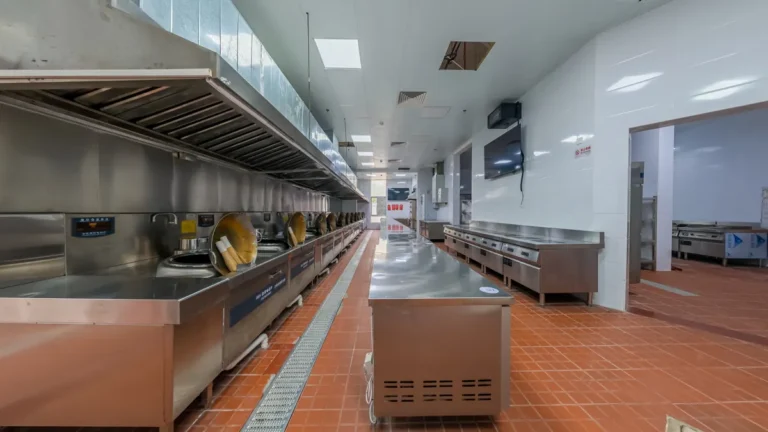 Commercial kitchen with tiled floor and drainage channel, illustrating back-of-house flooring choices between vinyl, rubber and epoxy