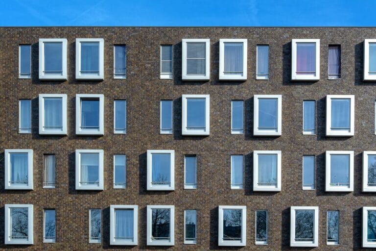 Brick building facade with projecting framed windows in a regular grid