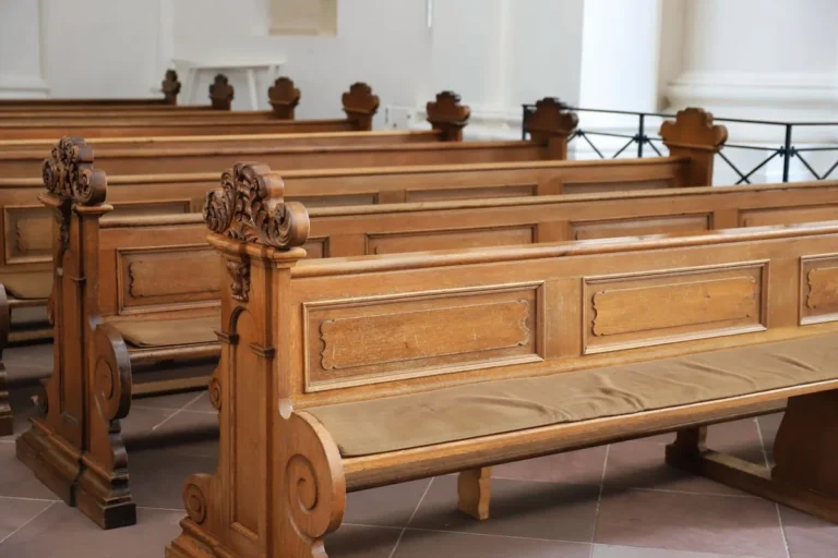 Carved timber pews in a worship building, representing seating and finishes for church and worship centre projects