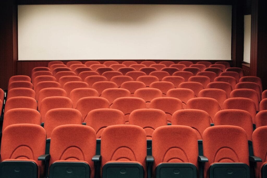 Empty cinema auditorium with fixed tiered seating facing the screen