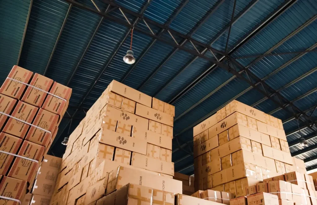 Stacked cartons in a warehouse before loading, the cartons a container loading report reconciles against the packing list