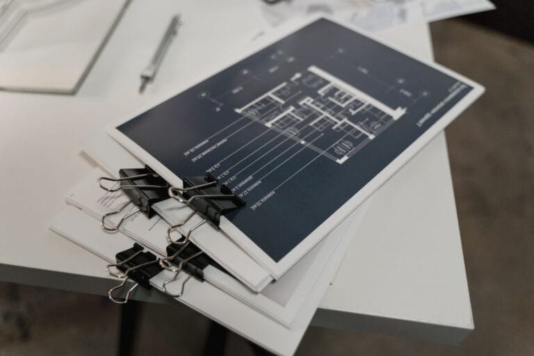 Stack of architectural floor plan drawings bound with clips, illustrating project records used to match a delivered China procurement package