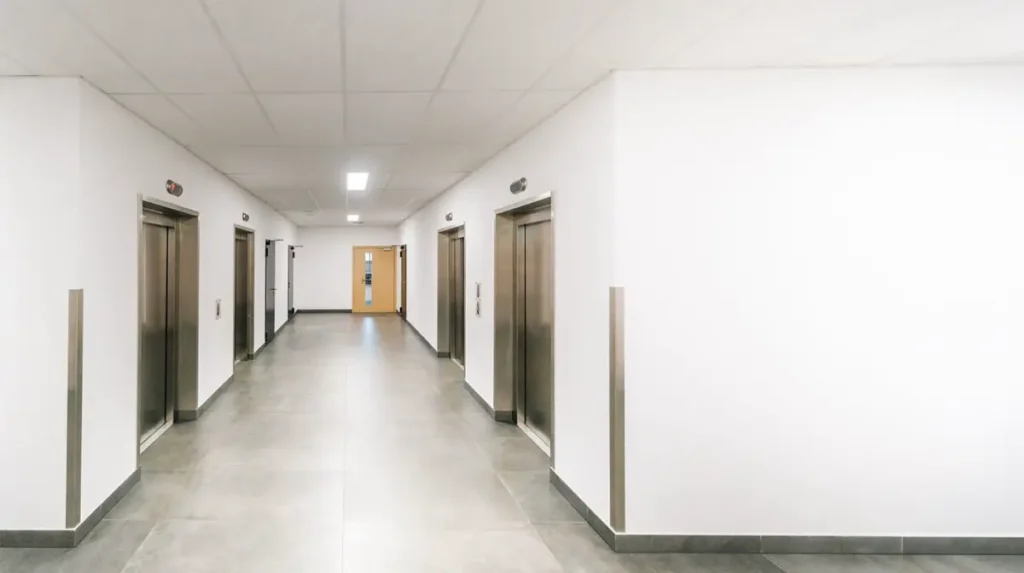 Building corridor with lift doors and a fire-rated door set - fire-rated doorsets from China for Australian projects under the NCC