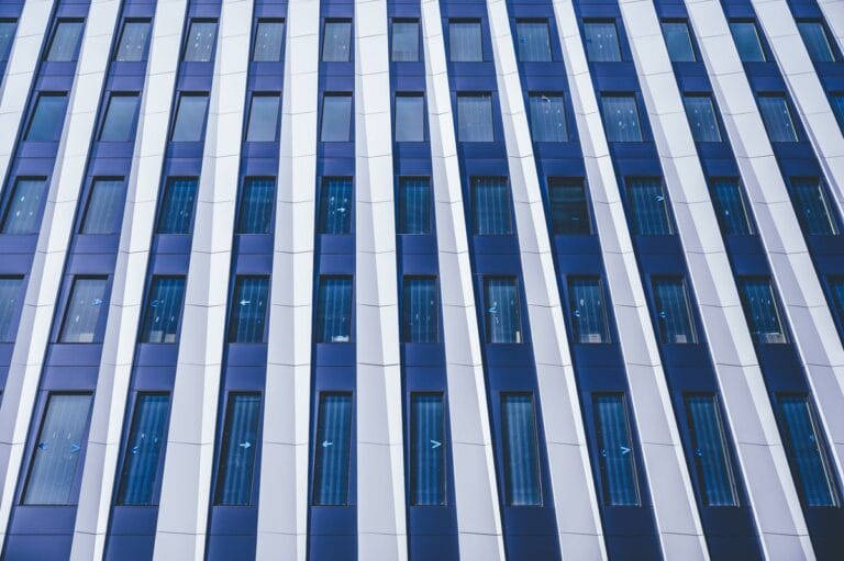Close-up of a multi-storey building facade of composite cladding panels and windows, illustrating Gulf fire and life-safety approval requirements