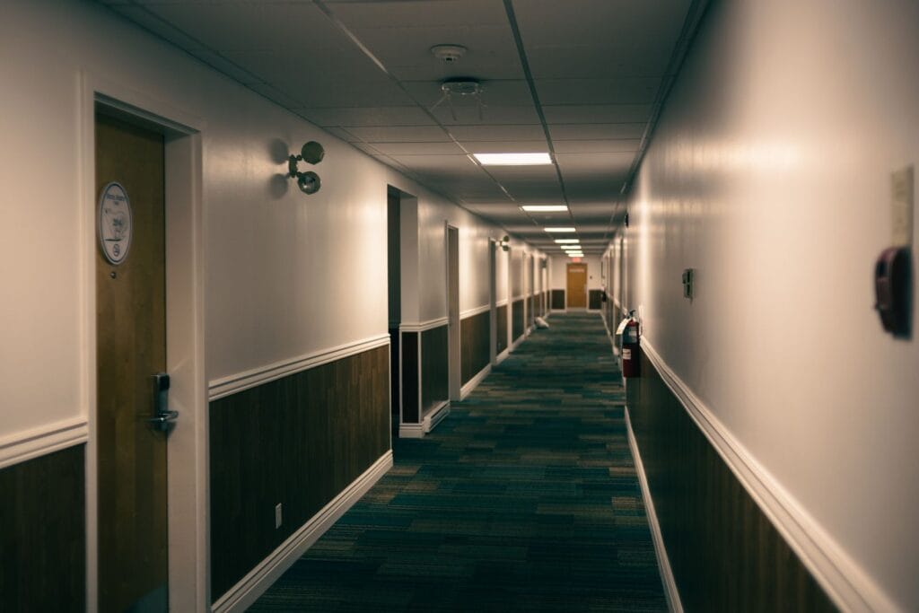 Hotel corridor lined with timber-faced guest room doors