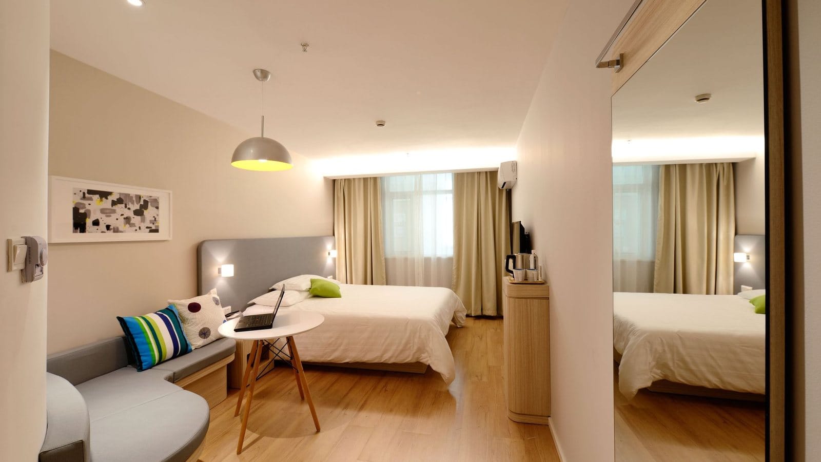 Hotel guestroom with headboard, side table and built-in casegoods