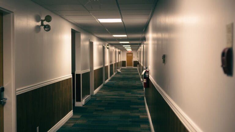 Hotel guestroom corridor with timber doors and wall panelling
