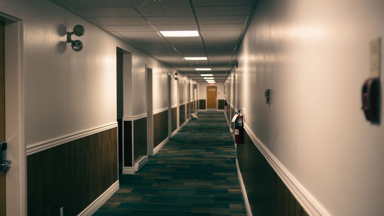 Hotel guestroom corridor with timber doors and wall panelling