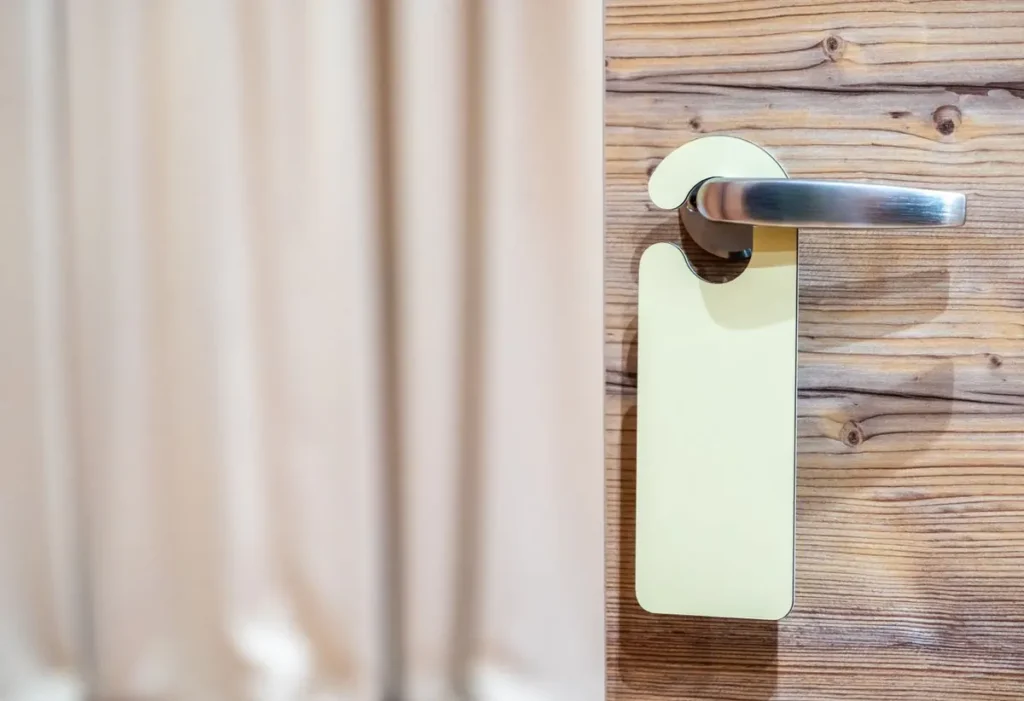 Hotel guest room door with a stainless steel lever handle and door hanger, illustrating hotel lock manufacturers in China