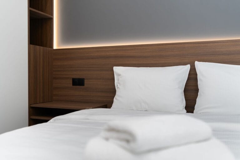 Hotel guest room with timber headboard panelling and white linen, illustrating FF&E sourced from China for a Middle East hotel project