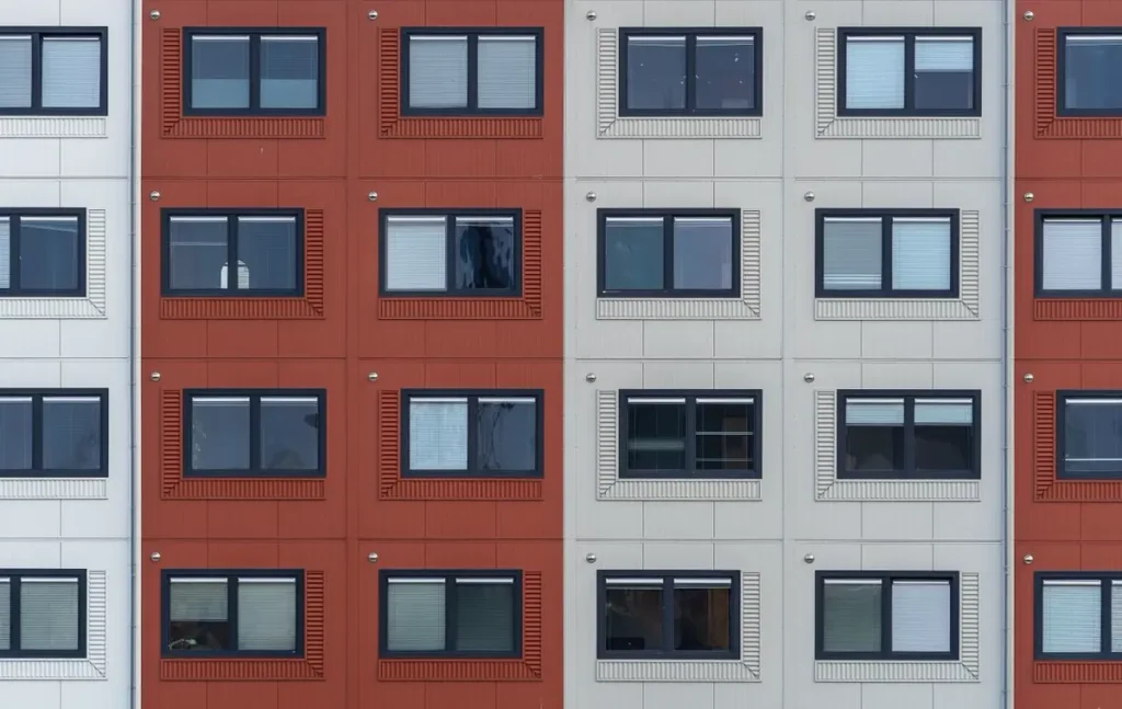 Multifamily apartment facade with repeated white-framed windows — uPVC window and profile manufacturers in China for multifamily projects