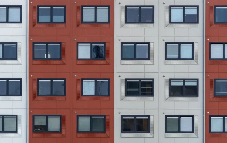 Multifamily apartment facade with repeated white-framed windows — uPVC window and profile manufacturers in China for multifamily projects