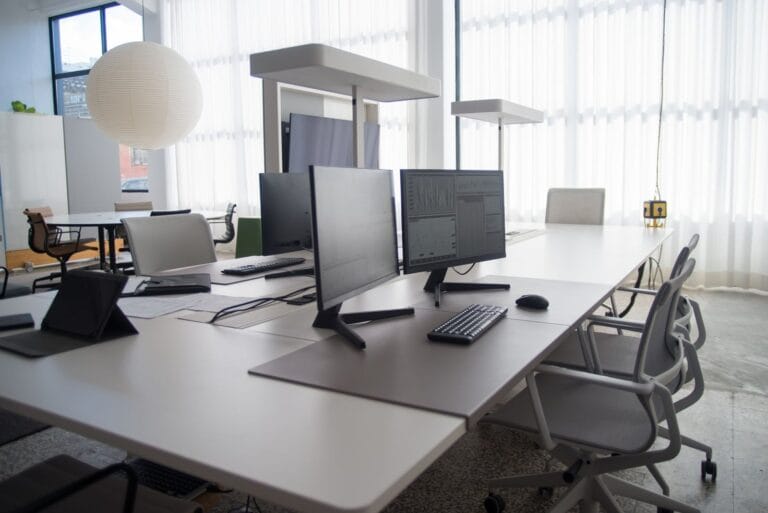 Open-plan office workstations with monitors and task chairs